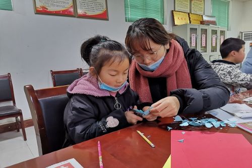 志愿者教孩子剪纸.jpg
