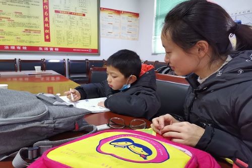 志愿者辅导孩子做数学题.jpg